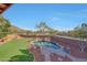 An elevated view of a private backyard with a pool, desert landscaping, and patio area at 25767 N 67Th Dr, Peoria, AZ 85383