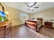Cozy bedroom with wood floors, a ceiling fan, neutral walls, and a large wooden sleigh bed at 25767 N 67Th Dr, Peoria, AZ 85383