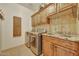 Laundry room with wooden cabinets, granite countertops, a sink, and stainless steel appliances at 25767 N 67Th Dr, Peoria, AZ 85383