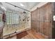 Main bathroom with a walk-in shower with glass doors, wood plank walls, and wood floors at 25767 N 67Th Dr, Peoria, AZ 85383