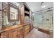 Main bathroom featuring double sinks, wooden cabinets, and a glass-enclosed shower at 25767 N 67Th Dr, Peoria, AZ 85383
