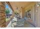 Covered patio with stone columns, outdoor table and chairs, ceiling fans, and view to backyard at 25767 N 67Th Dr, Peoria, AZ 85383