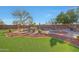 Inviting backyard with a freeform pool, lush lawn, and desert landscaping for outdoor enjoyment at 25767 N 67Th Dr, Peoria, AZ 85383
