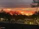 A vibrant sunset view showcasing the sky's fiery colors over a neighborhood landscape at 25767 N 67Th Dr, Peoria, AZ 85383