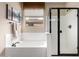 Bathroom featuring a bathtub, a shower with a glass door and a window at 27071 N 172Nd Ln, Surprise, AZ 85387
