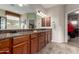 Bathroom featuring dual sinks, granite countertops and an open doorway to the closet at 27071 N 172Nd Ln, Surprise, AZ 85387