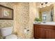 Cozy powder room featuring floral wallpaper, a dark vanity, and a white toilet at 27071 N 172Nd Ln, Surprise, AZ 85387
