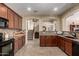 Bright and spacious kitchen with tile floors, dark cabinets, stainless steel appliances, and granite countertops at 27071 N 172Nd Ln, Surprise, AZ 85387