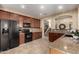 Well-lit kitchen with granite countertops, dark cabinets, tile backsplash, and modern appliances at 27071 N 172Nd Ln, Surprise, AZ 85387