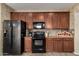 Modern kitchen with dark cabinets, stainless steel appliances, and granite countertops at 27071 N 172Nd Ln, Surprise, AZ 85387