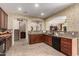 Spacious kitchen with granite countertops, dark cabinetry, tile backsplash, and stainless steel appliances at 27071 N 172Nd Ln, Surprise, AZ 85387