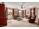 Warm living room with a ceiling fan, carpet floors, and a cozy seating area at 27071 N 172Nd Ln, Surprise, AZ 85387
