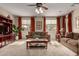 Bright living room with two sofas, TV, large windows, decorative curtains, and neutral carpet at 27071 N 172Nd Ln, Surprise, AZ 85387