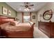 Spacious main bedroom showcasing a wooden dresser, a ceiling fan and a window at 27071 N 172Nd Ln, Surprise, AZ 85387