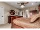 Spacious main bedroom featuring a ceiling fan, a wooden dresser and a decorative round mirror at 27071 N 172Nd Ln, Surprise, AZ 85387