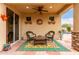 Inviting covered patio featuring a cozy seating area with a colorful rug and a glimpse of the sparkling pool at 27071 N 172Nd Ln, Surprise, AZ 85387