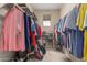 Walk-in closet with rods, shelves and a variety of shoes and hanging clothes at 27071 N 172Nd Ln, Surprise, AZ 85387