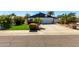 Charming single-Gathering home with a well-manicured lawn, palm trees, and a basketball hoop above the garage at 2717 E Aster Dr, Phoenix, AZ 85032