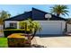 View of the garage with a basketball hoop and tropical landscaping surrounding the driveway and facade at 2717 E Aster Dr, Phoenix, AZ 85032