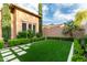 Lush backyard with artificial grass, clean landscape and stone path, ideal for low-maintenance living at 28834 N 68Th Ave, Peoria, AZ 85383