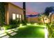 Beautifully landscaped backyard with a turf area, illuminated for evening enjoyment at 28834 N 68Th Ave, Peoria, AZ 85383