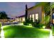 Lush backyard with green turf, travertine stepping stones, a pool, and a covered patio at 28834 N 68Th Ave, Peoria, AZ 85383