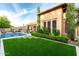 Lush backyard with artificial grass, pool, clean landscape and stone path, ideal for low-maintenance living at 28834 N 68Th Ave, Peoria, AZ 85383