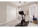 Home exercise room with neutral paint, carpet flooring, stationary bike, and natural light at 28834 N 68Th Ave, Peoria, AZ 85383