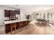 Open-concept kitchen and dining area featuring a large island with seating, stainless appliances, and hardwood floors at 28834 N 68Th Ave, Peoria, AZ 85383