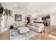 Open concept living room with an island, white sofas, light color hardwood floors, and an island at 28834 N 68Th Ave, Peoria, AZ 85383