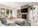 Comfortable living room featuring a stone fireplace, a large window, and natural lighting at 28834 N 68Th Ave, Peoria, AZ 85383