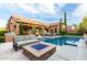Inviting backyard oasis with a sparkling pool, outdoor seating, and a cozy fire pit for relaxation at 28834 N 68Th Ave, Peoria, AZ 85383