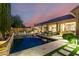Serene backyard pool area with a built-in barbecue, elegant landscaping, and comfortable seating at 28834 N 68Th Ave, Peoria, AZ 85383