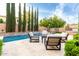 Bright backyard pool featuring a stone wall, outdoor seating, and travertine tile at 28834 N 68Th Ave, Peoria, AZ 85383
