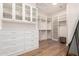 Spacious walk-in closet featuring custom shelves, cabinets, drawers, and wood floors at 28834 N 68Th Ave, Peoria, AZ 85383