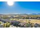Expansive aerial view of desert homes showcases community layout against a mountain backdrop under a clear blue sky at 29794 N Little Leaf Dr, San Tan Valley, AZ 85143