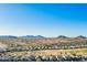 Scenic aerial view of desert homes presents community near picturesque mountains under a clear blue sky at 29794 N Little Leaf Dr, San Tan Valley, AZ 85143