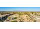 High-angle aerial view showcases desert homes surrounding a golf course, complemented by distant mountain vistas at 29794 N Little Leaf Dr, San Tan Valley, AZ 85143