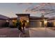 Charming one-story home featuring a stone facade, desert landscaping, and a two-car garage at dusk at 29794 N Little Leaf Dr, San Tan Valley, AZ 85143