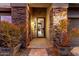 Inviting home entrance with brick accents, beautiful plants, and a security screen door at 29794 N Little Leaf Dr, San Tan Valley, AZ 85143
