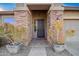 Inviting front entrance features decorative columns, potted plants, and a charming door with sidelight at 29794 N Little Leaf Dr, San Tan Valley, AZ 85143