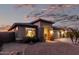 Twilight view of a single-story home with desert landscaping, stone accents and a two-car garage at 29794 N Little Leaf Dr, San Tan Valley, AZ 85143