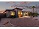 Twilight view of a single-story home with desert landscaping, stone accents and a two-car garage at 29794 N Little Leaf Dr, San Tan Valley, AZ 85143