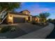 Exterior of a home at dusk with a brick driveway, two-car garage, and desert landscaping at 30311 N 52Nd Pl, Cave Creek, AZ 85331