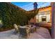 Inviting patio with stone fire pit, outdoor seating, string lights, and lush wall greenery for cozy evenings at 30311 N 52Nd Pl, Cave Creek, AZ 85331
