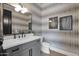 Stylish powder room featuring patterned wallpaper and a gray vanity with a white countertop at 3173 E Page Ave, Gilbert, AZ 85234