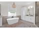 Relaxing bathroom with a freestanding tub, stylish chandelier, and modern white cabinetry at 3173 E Page Ave, Gilbert, AZ 85234