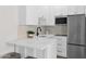Contemporary kitchenette with white cabinets, stainless steel appliances, and marble countertops at 3173 E Page Ave, Gilbert, AZ 85234