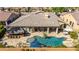 Aerial view of an inviting backyard oasis with a sparkling pool, spa, covered patio, and tiki bar at 3353 E Nolan Dr, Chandler, AZ 85249