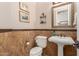 Stylish powder room featuring a pedestal sink, wainscoting, and decorative art at 3353 E Nolan Dr, Chandler, AZ 85249